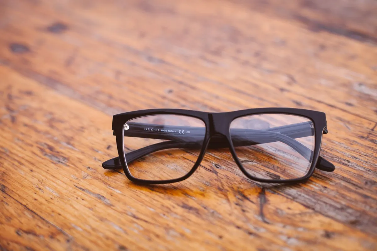 Anteojos de marco negro sobre una mesa de madera